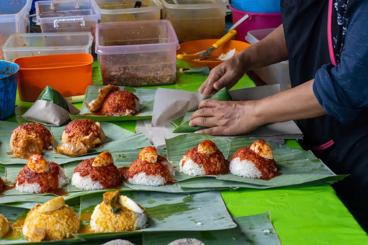 Street food malese, preparazione del Nasi Lemak Foto: Copyright © Sisterscom.com / Depositphotos
