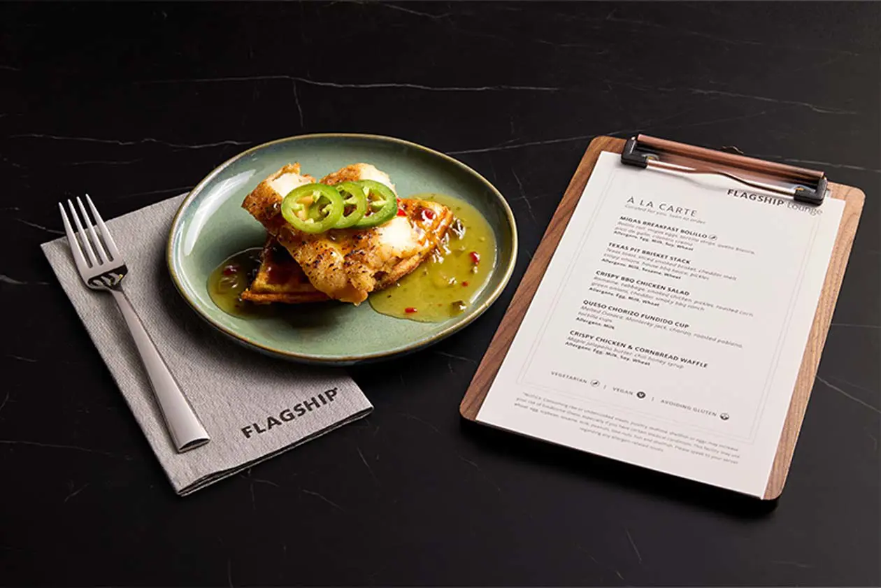 Nella lounge Flagship ® è possibile ordinare pollo croccante e waffle di pane di mais alla carta, con servizio di scansione del menu.